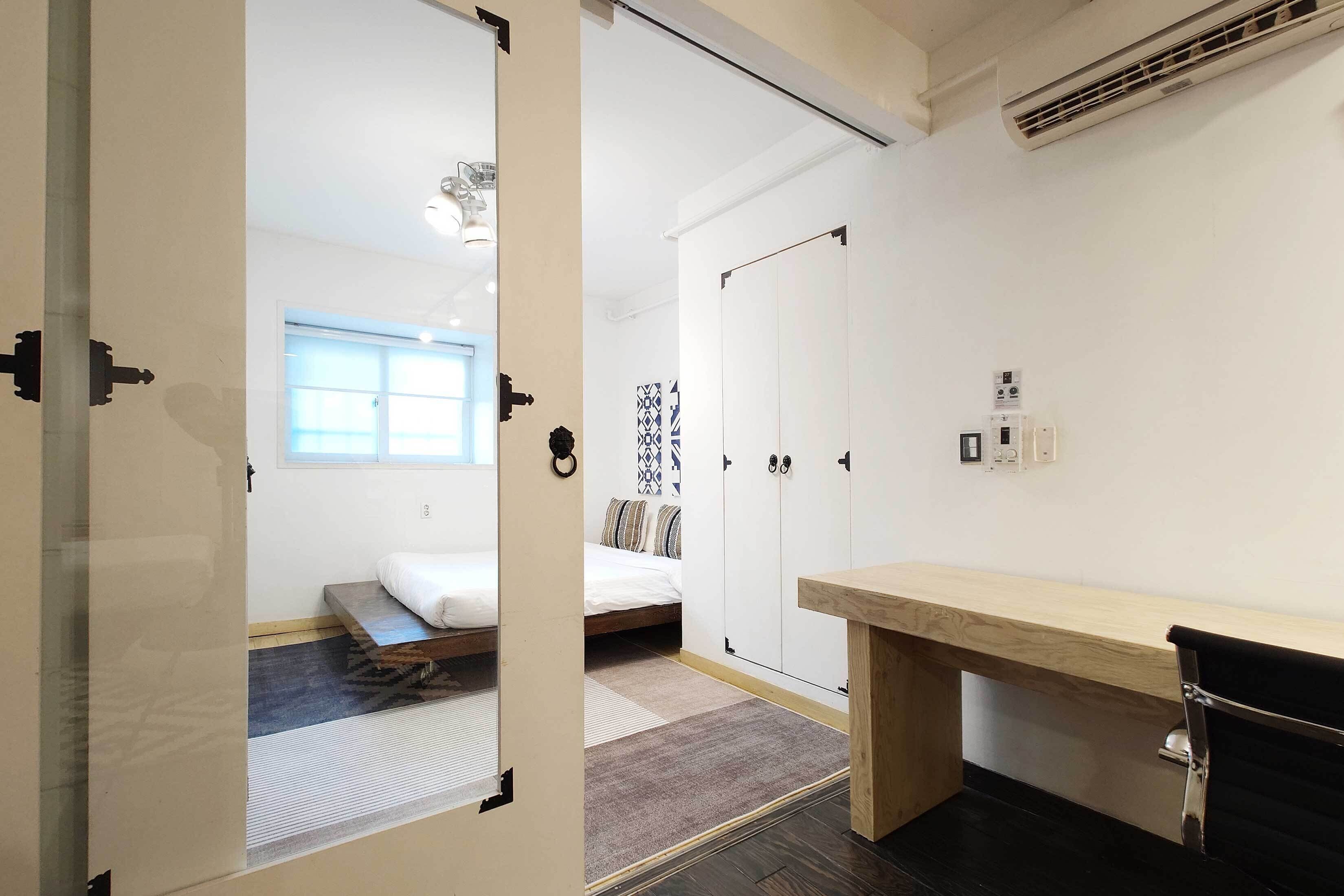 A hotel room with a bed, a desk, a wardrobe, and a window.