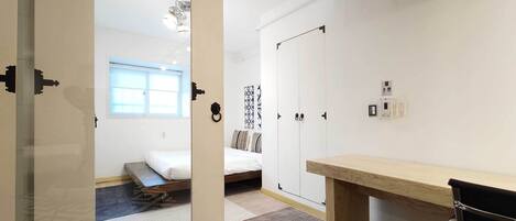 A hotel room with a bed, a desk, a wardrobe, and a window.