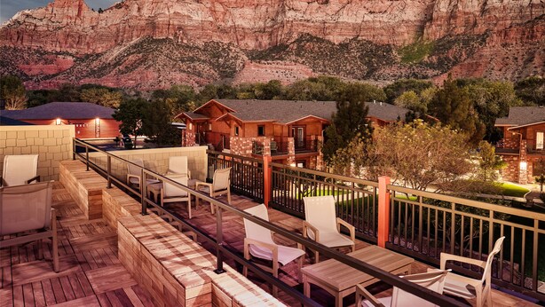 A wooden deck with outdoor seating, overlooking a mountainous landscape. - Cable Mountain Lodge (Springdale)