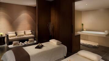 Un moderno espacio de spa con zona de masajes, una bañera y un mostrador de recepción.