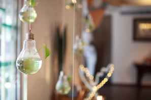 A room with hanging light bulbs containing green plants. - Cullinan Hotel (Hualien City)