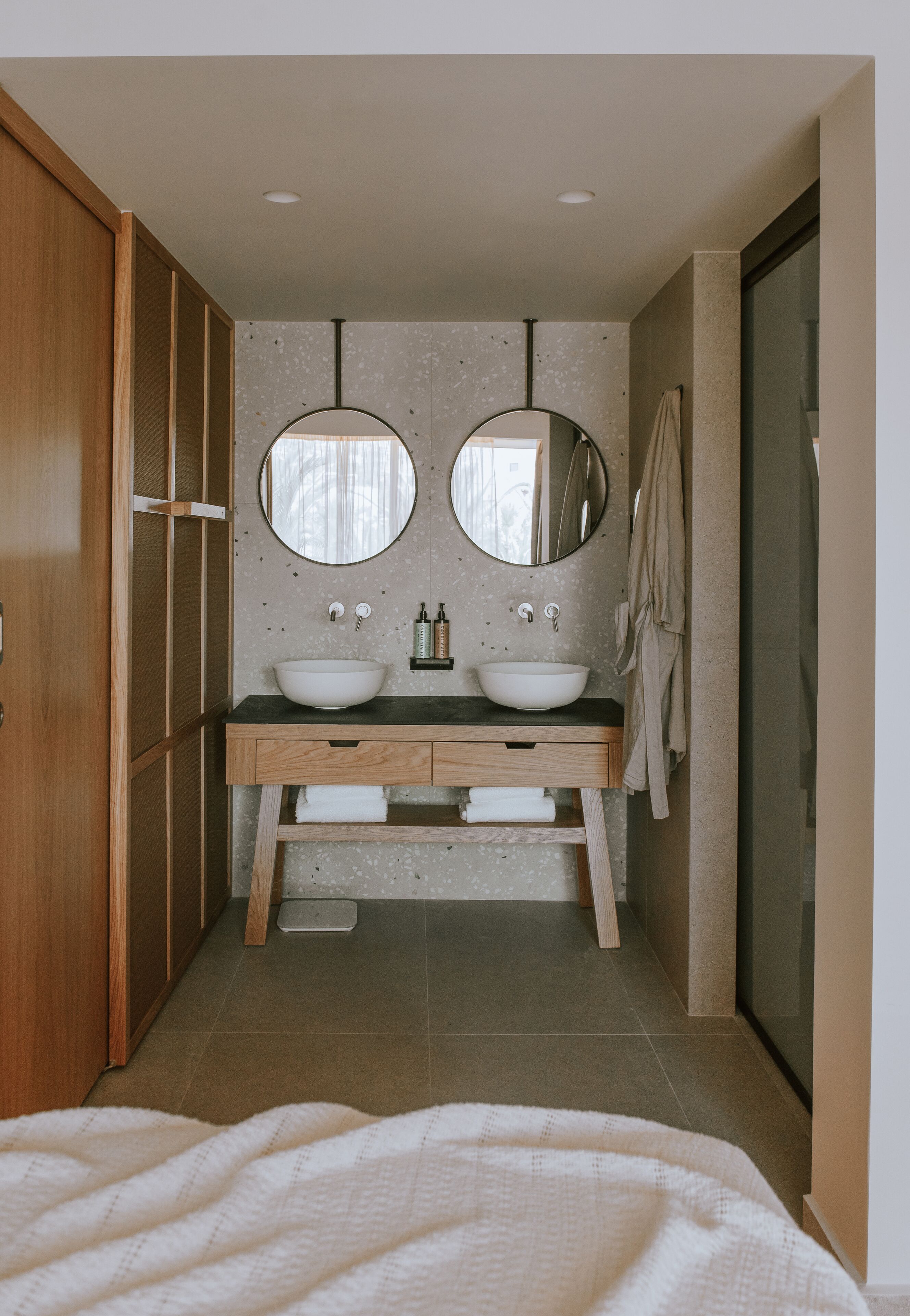 Ein Badezimmer mit zwei Waschbecken, Holzschränken und einem großen Spiegel.