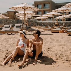 Na praia, espreguiçadeiras, guarda-sóis, toalhas de praia