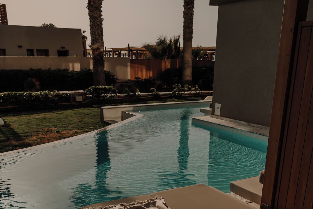 Eine Liegebereich am Pool mit gepolsterten Sitzgelegenheiten und Blick auf das Schwimmbecken.