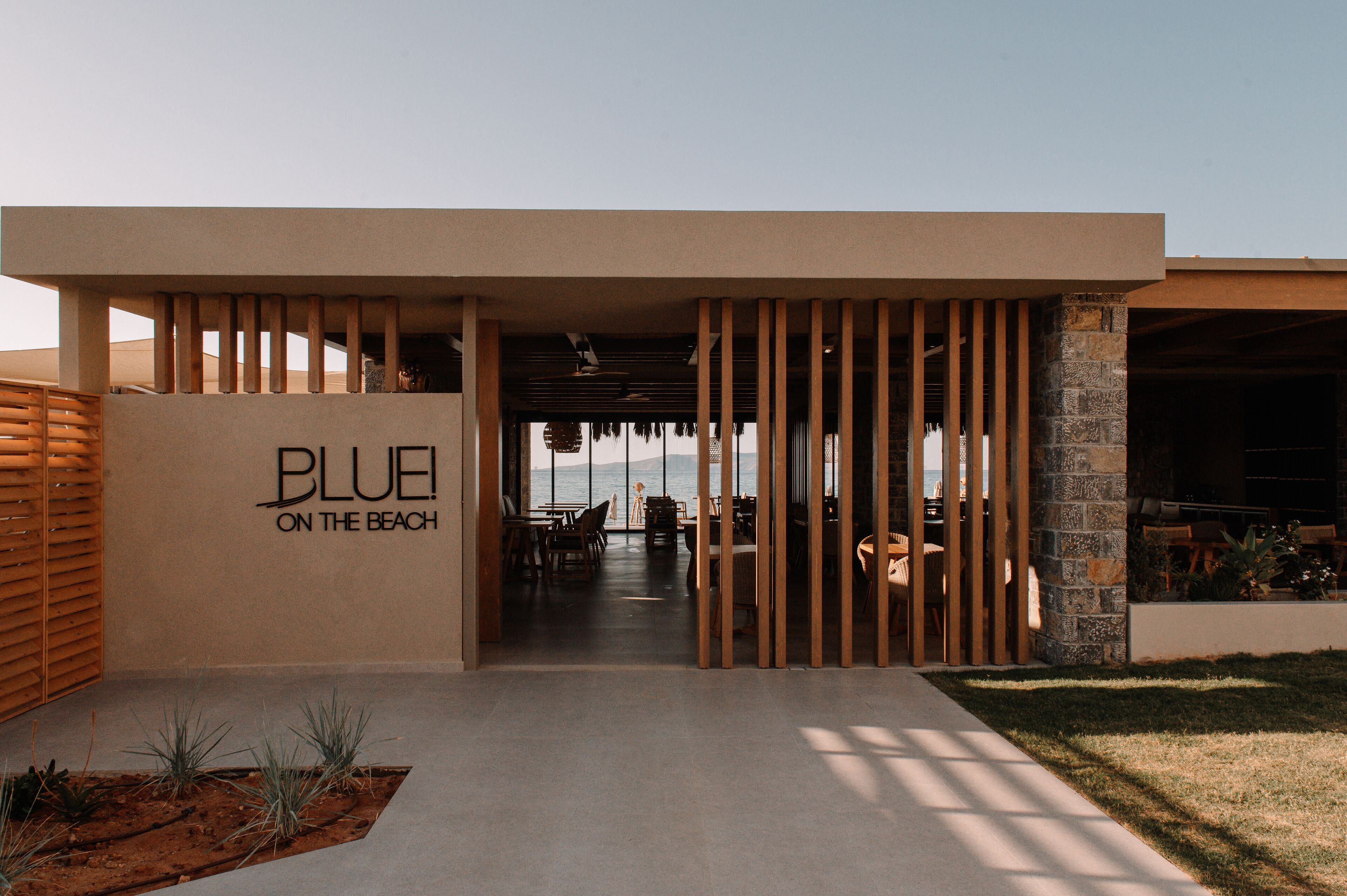 En modern byggnad med en skylt som visar texten ”BLUE ON THE BEACH”.