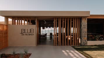En modern byggnad med en skylt som visar texten ”BLUE ON THE BEACH”.