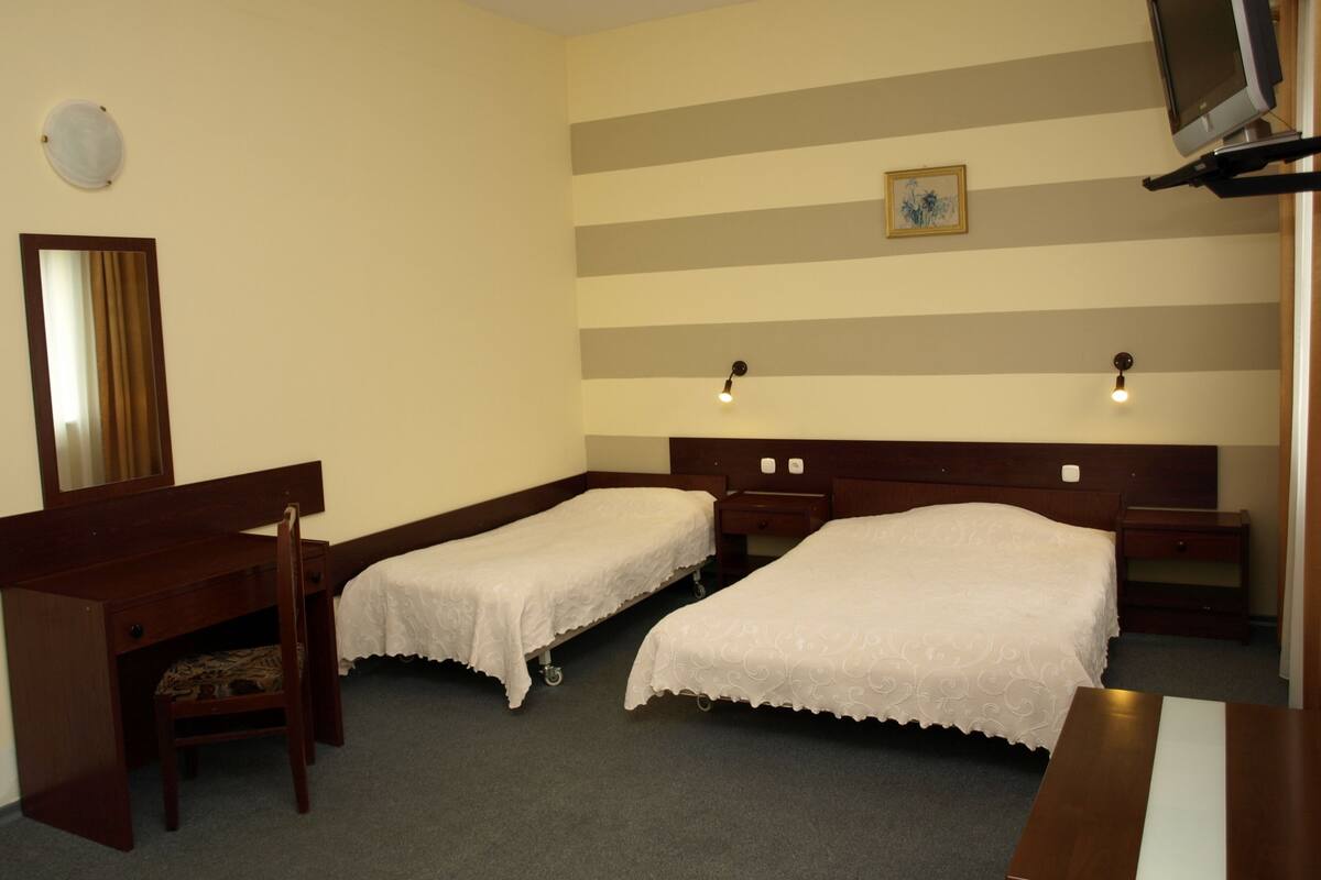 أغطية فراش متميزة وخزنة داخل الغرفة ومكتب وستائر تعتيم