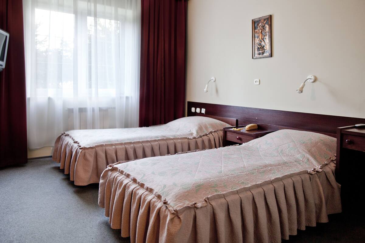 أغطية فراش متميزة وخزنة داخل الغرفة ومكتب وستائر تعتيم