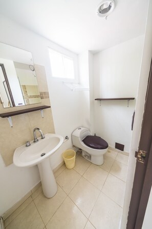 A small bathroom with a sink, toilet, and mirror. - Hotel Auaecoco (Cartagena)