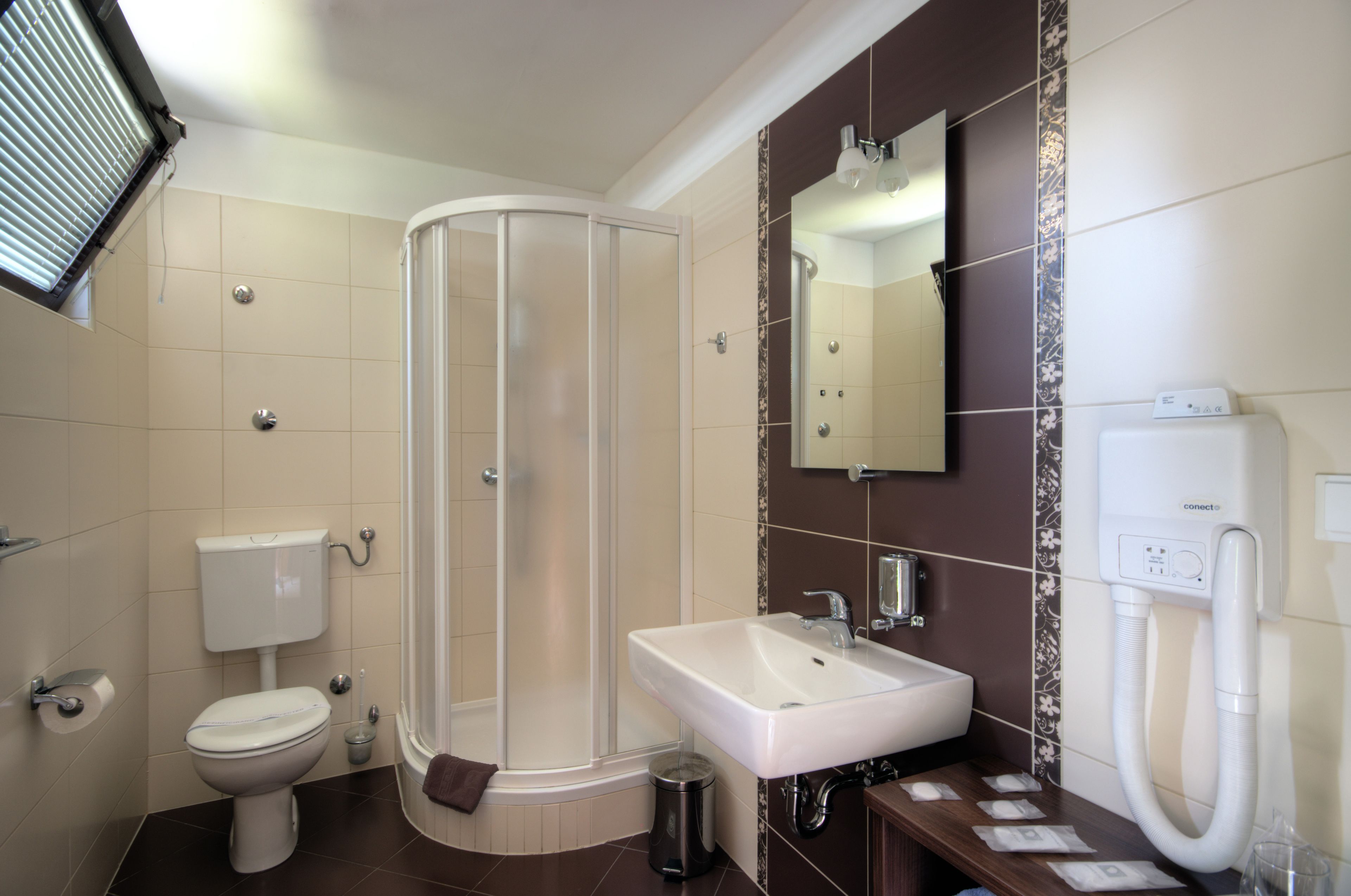 A modern bathroom with a shower, toilet, sink, and a mirror.