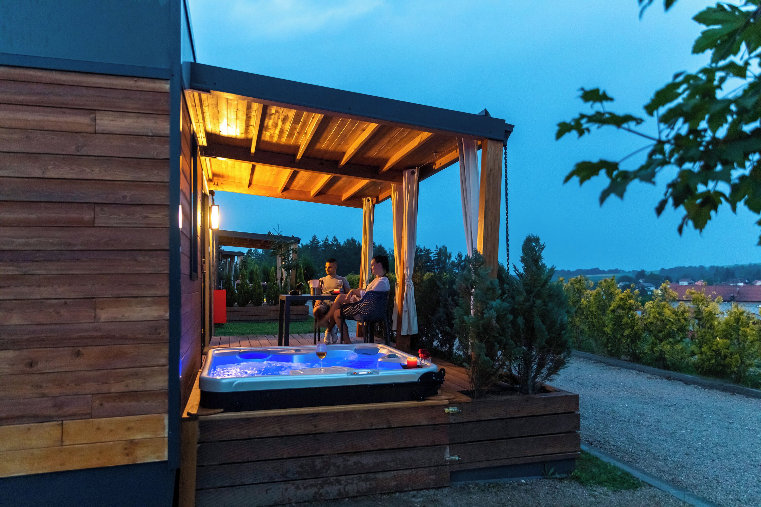 A wooden cabin with a hot tub and a covered patio area.