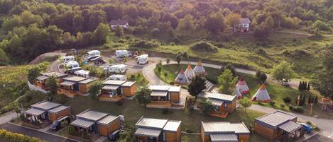 Un camping con varias cabañas, una carretera y tiendas de campaña.