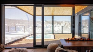 A modern interior with a large sliding glass door leading to a wooden deck with a hot tub. - Plitvice Holiday Resort - Campsite (Rakovica)