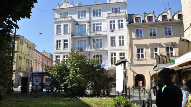 Un immeuble à plusieurs étages de style architectural traditionnel, doté de balcons et d’une cour intérieure.