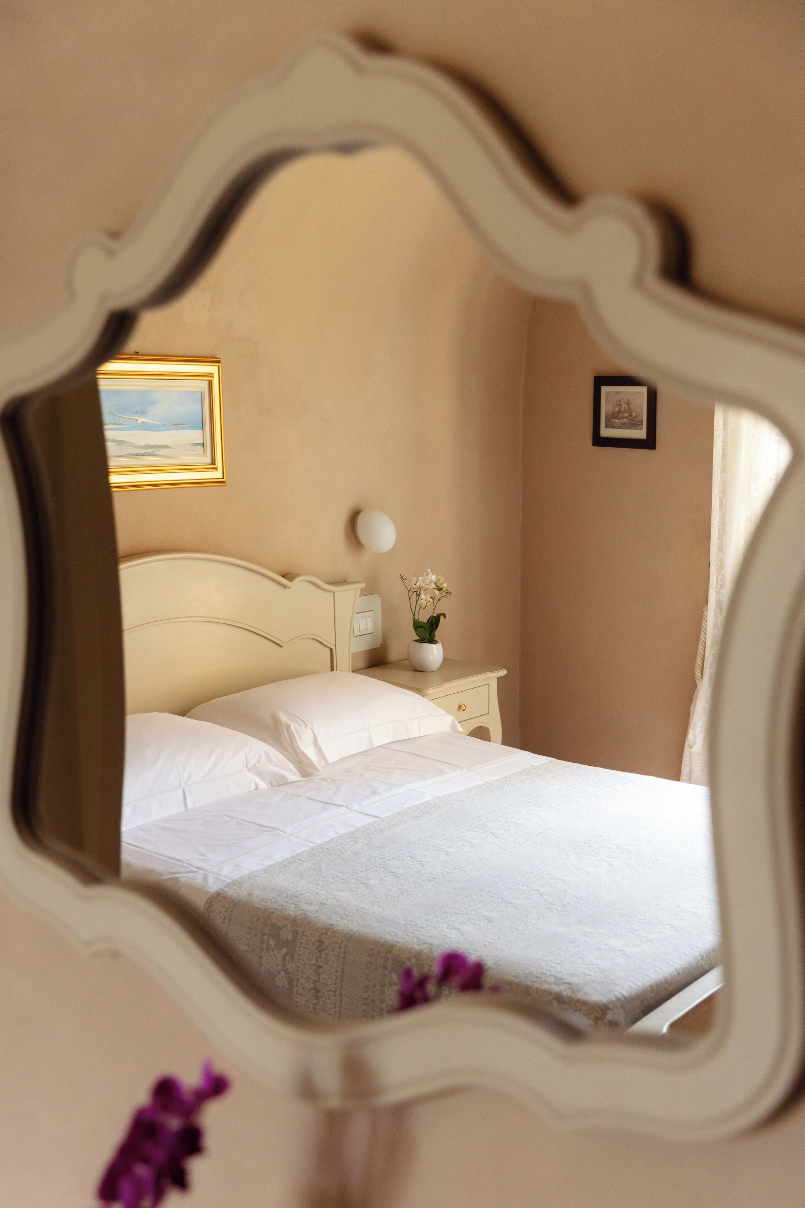 A bedroom with a bed, nightstand, and wall-mounted decor.