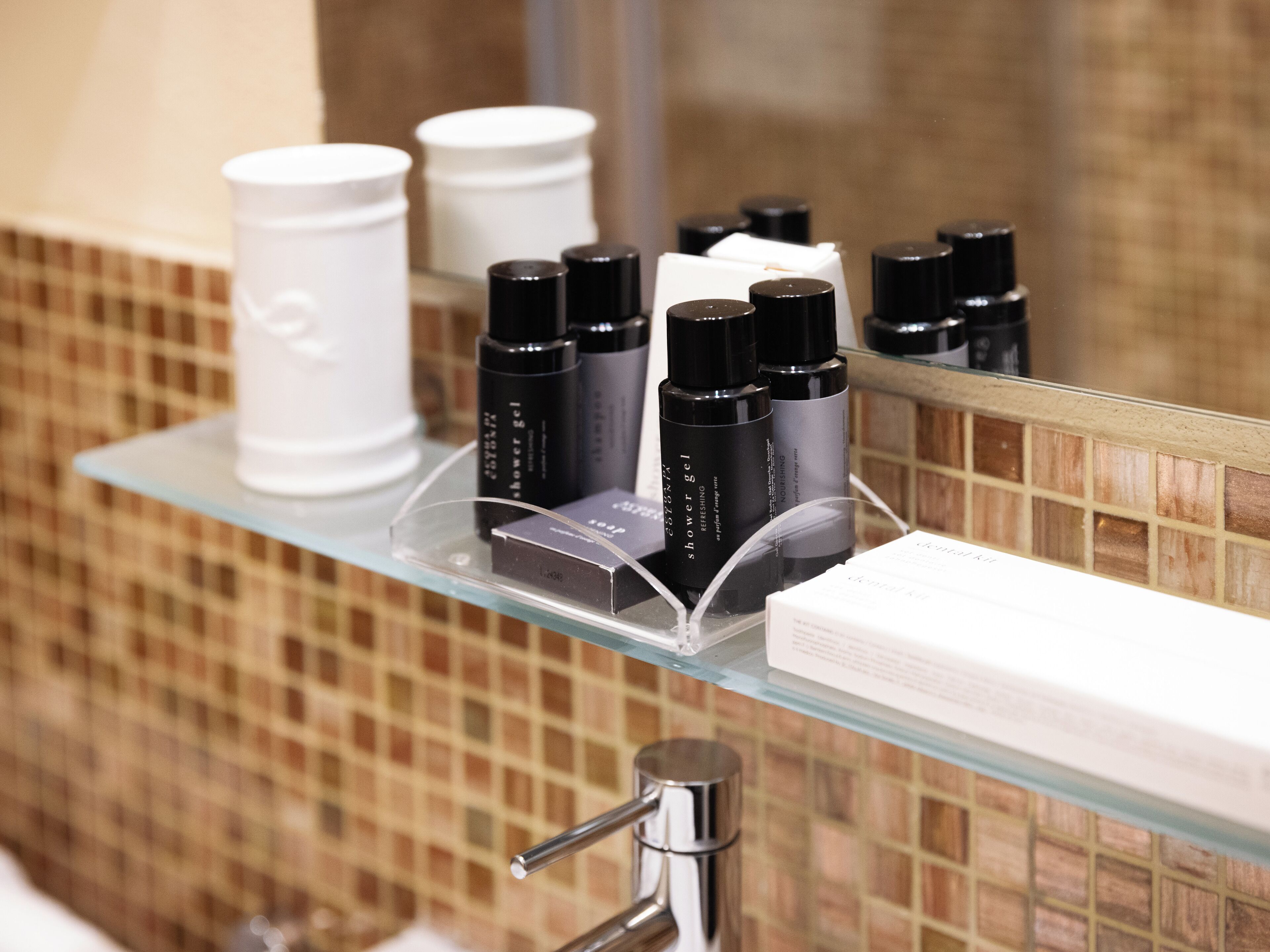 Un estante en el baño con diferentes artículos de aseo y una toalla blanca.