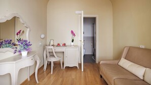 A room with a white vanity, a beige sofa, and a desk with a chair. - Residenza d'Epoca Relais I Miracoli (Pisa)