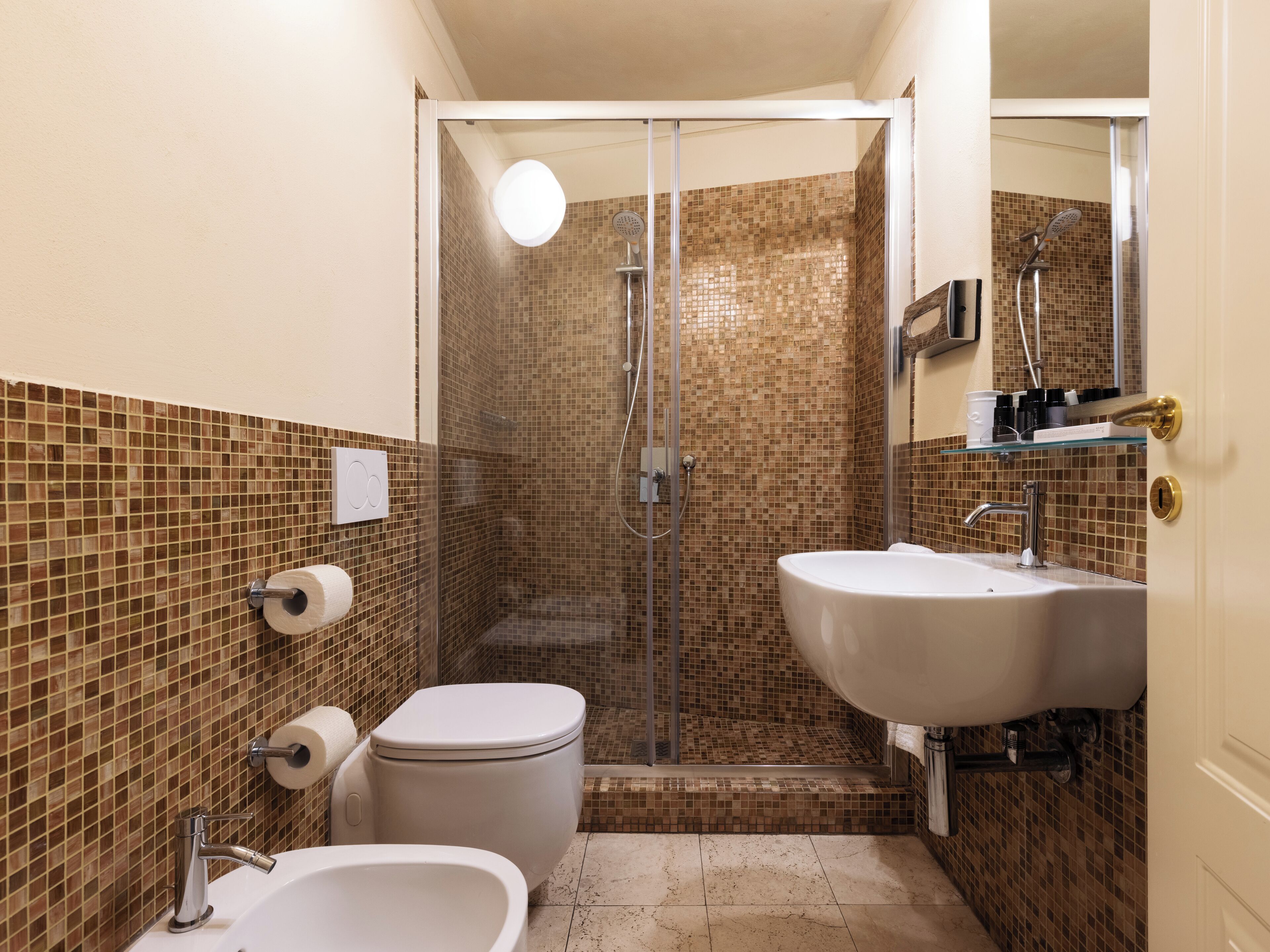 A bathroom with a shower, toilet, and sink.