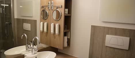 Un baño con dos lavamanos, un espejo y una ducha.