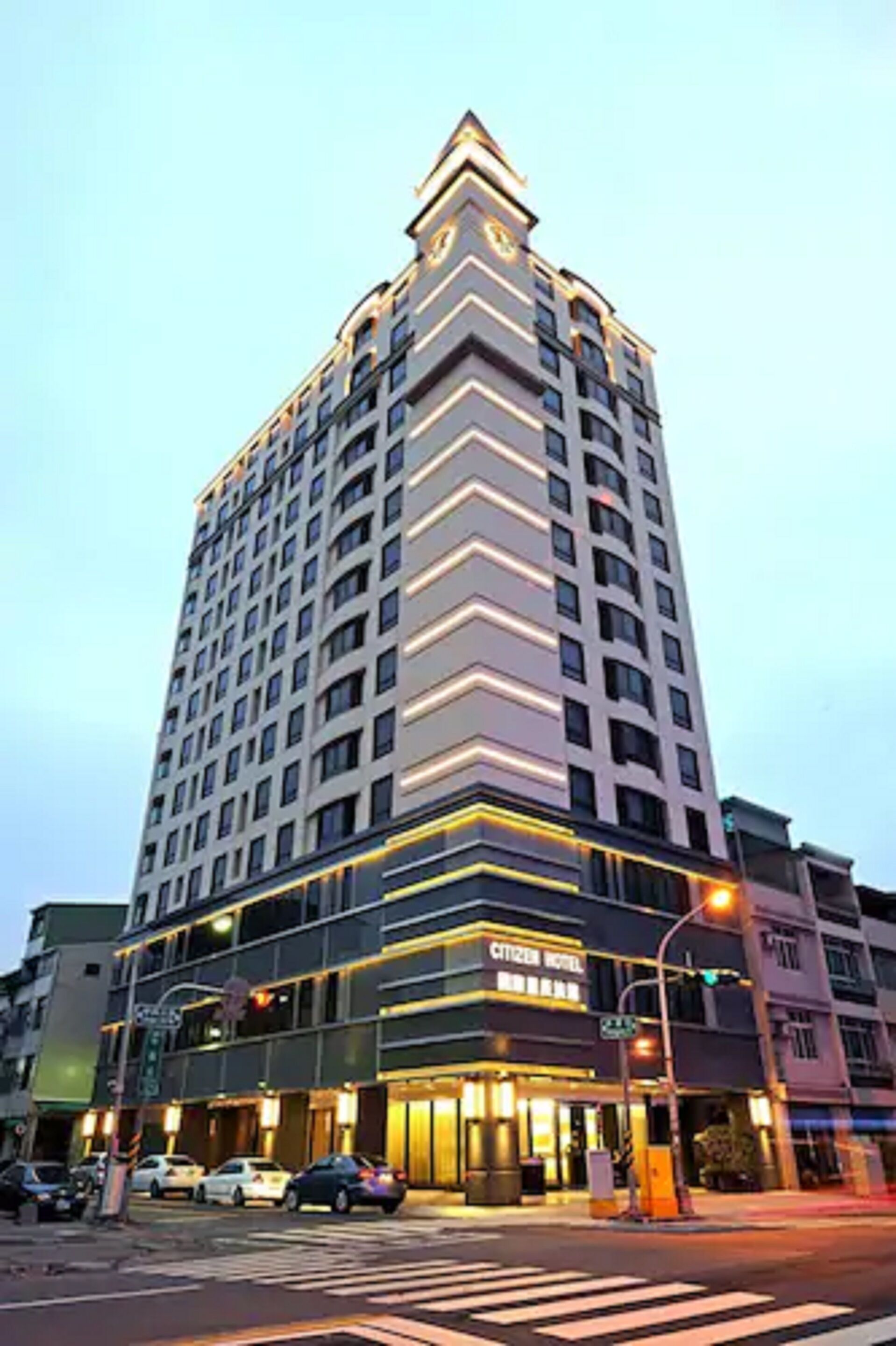 A tall hotel with a modern design, featuring multiple floors and a prominent entrance.