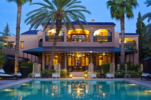 Una piscina al aire libre, sombrillas, tumbonas