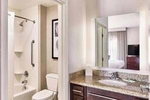 Enjoy a refreshing shower or soak in the standalone bathtub in this clean and functional bathroom.