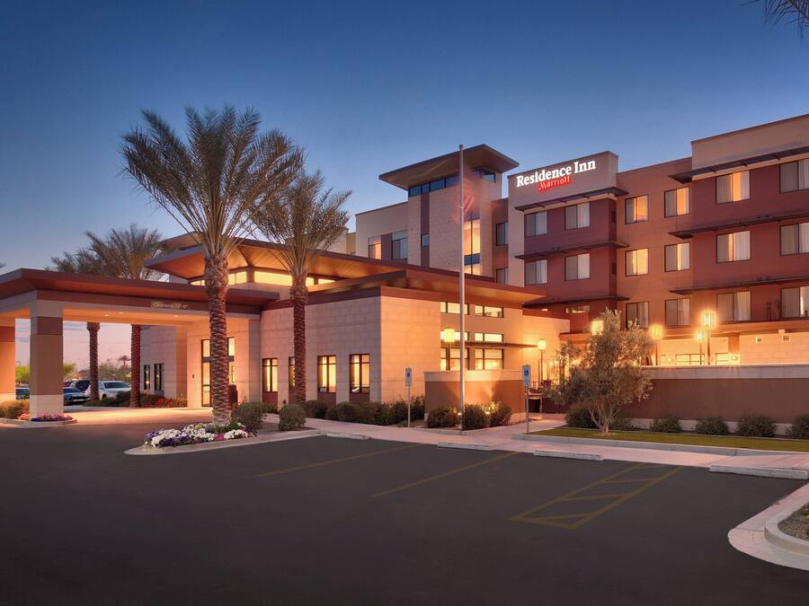 Un hotel Marriott con un diseño moderno, que cuenta con una entrada destacada, un área de estacionamiento y una fachada bien iluminada.