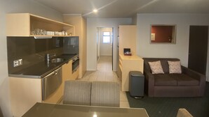 A compact living space with a kitchenette, a dining area, and a seating area with a couch.