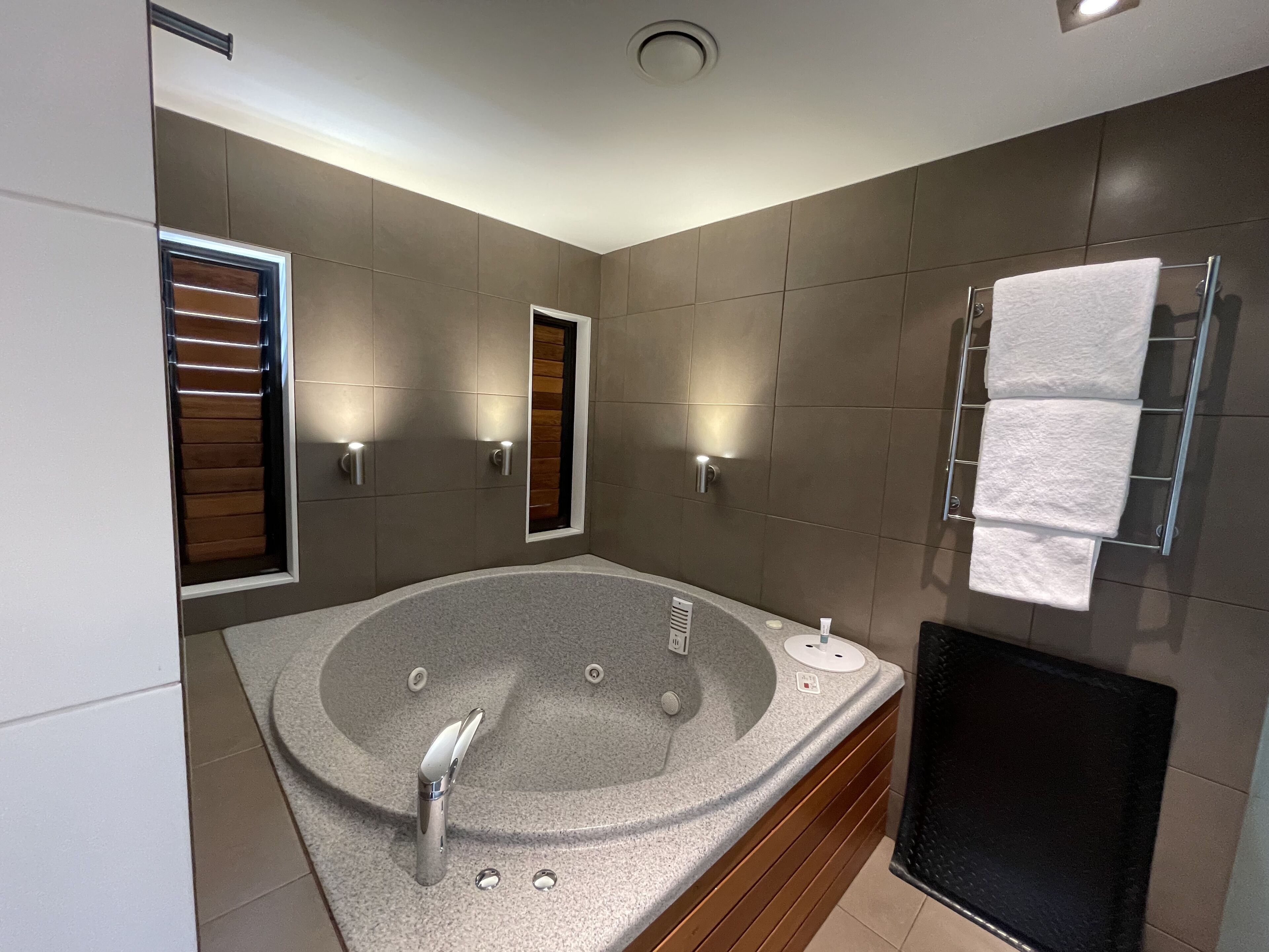 Une salle de bain moderne avec une baignoire sur pieds, un porte-serviettes mural et une douche intégrée.