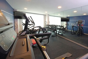 A gym with treadmills, dumbbells, and exercise machines.