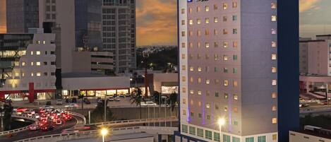 A Holiday Inn Express hotel with a parking lot and surrounding urban buildings.