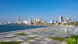 A waterfront promenade with a checkered pavement, seating areas, and a city skyline in the background. - Holiday Inn Express Veracruz Boca Del Rio by IHG (Boca del Río)