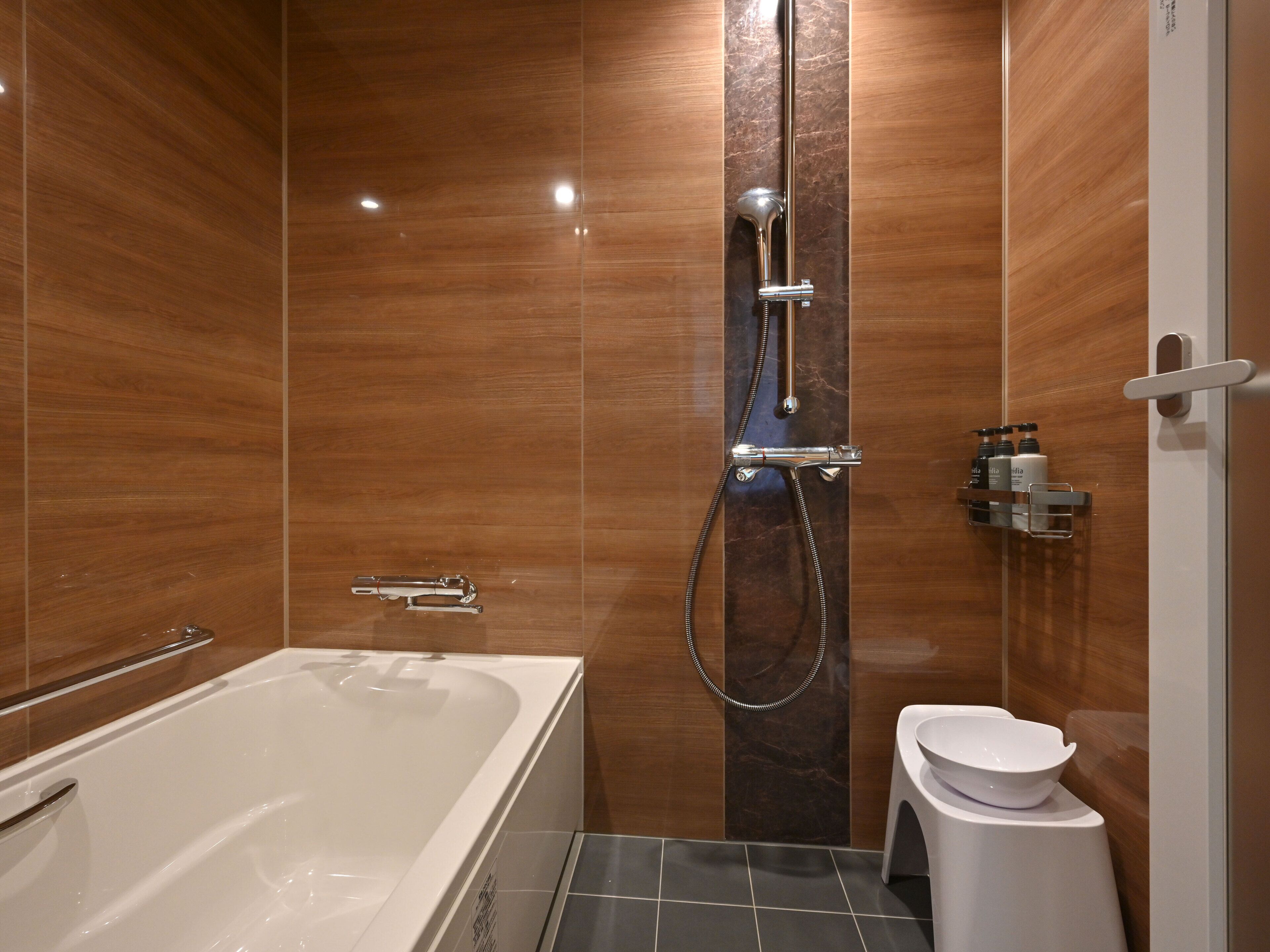 A modern bathroom with a bathtub, shower, and toilet.