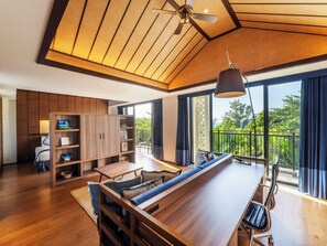A modern interior with a long wooden dining table, a built-in bookshelf, and a ceiling fan. - Fusaki Beach Resort Hotel & Villas (Ishigaki)