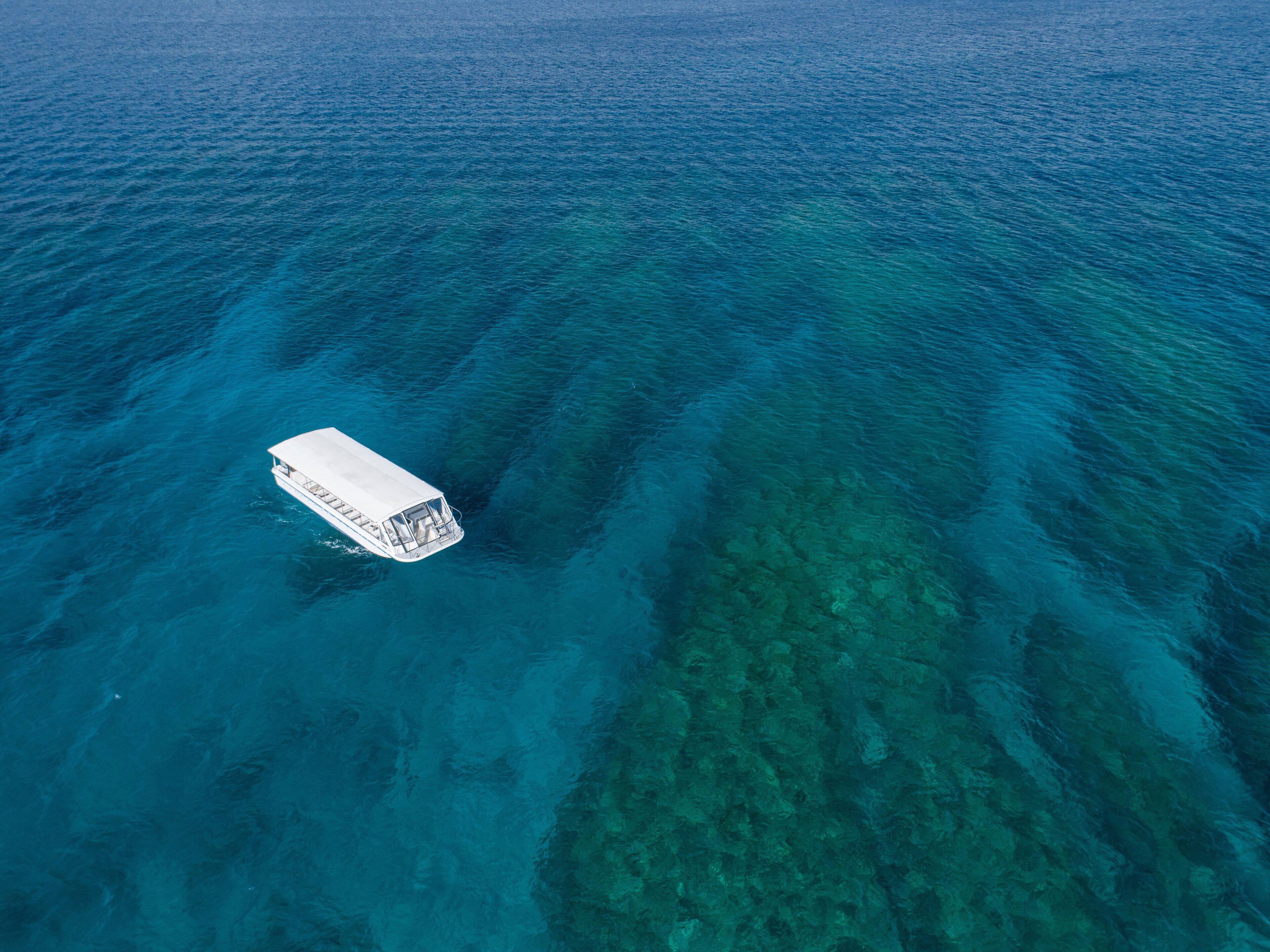 An aerial view of a boat on clear blue water.