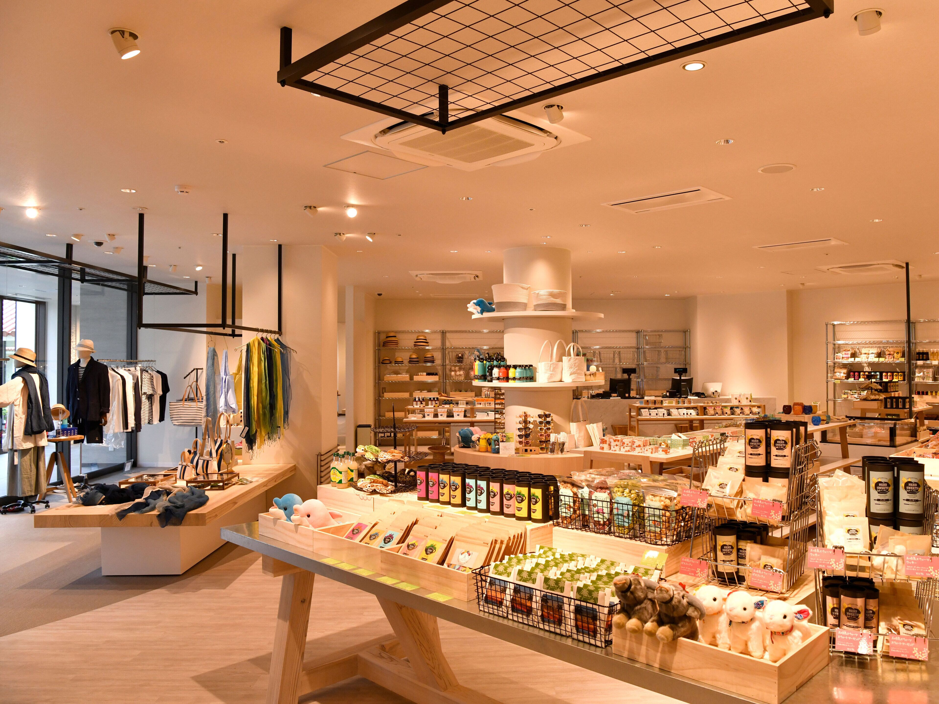 A well-lit retail store with various products on display, including handbags, accessories, and food items.