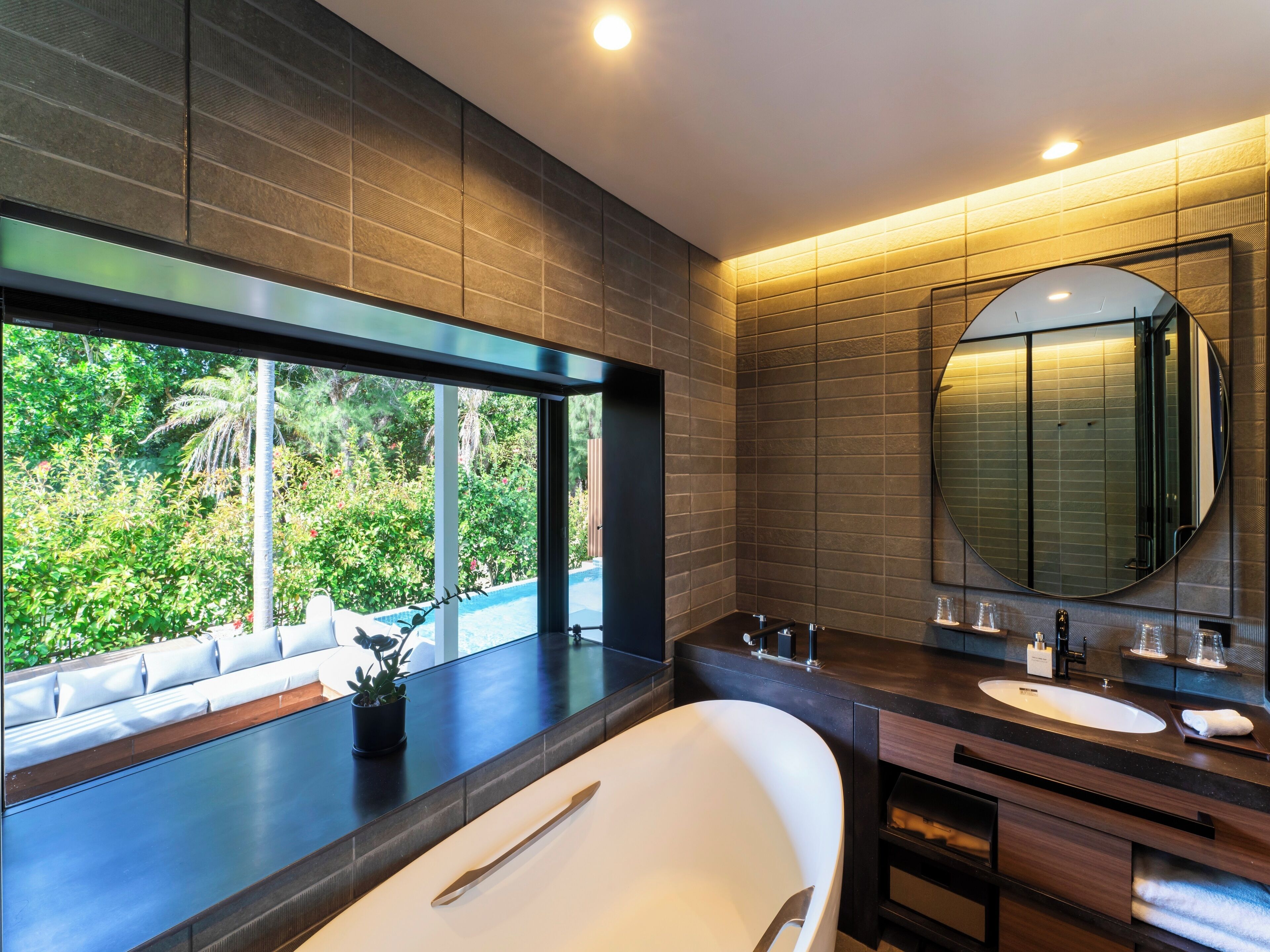 Une salle de bain moderne avec une grande baignoire, deux lavabos et un grand miroir.