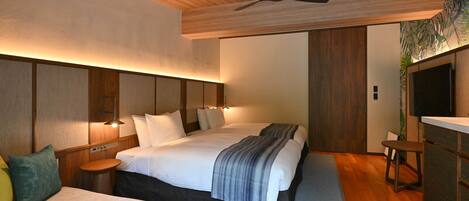 A modern hotel room with a large bed, bedside tables, a desk, and a ceiling fan.