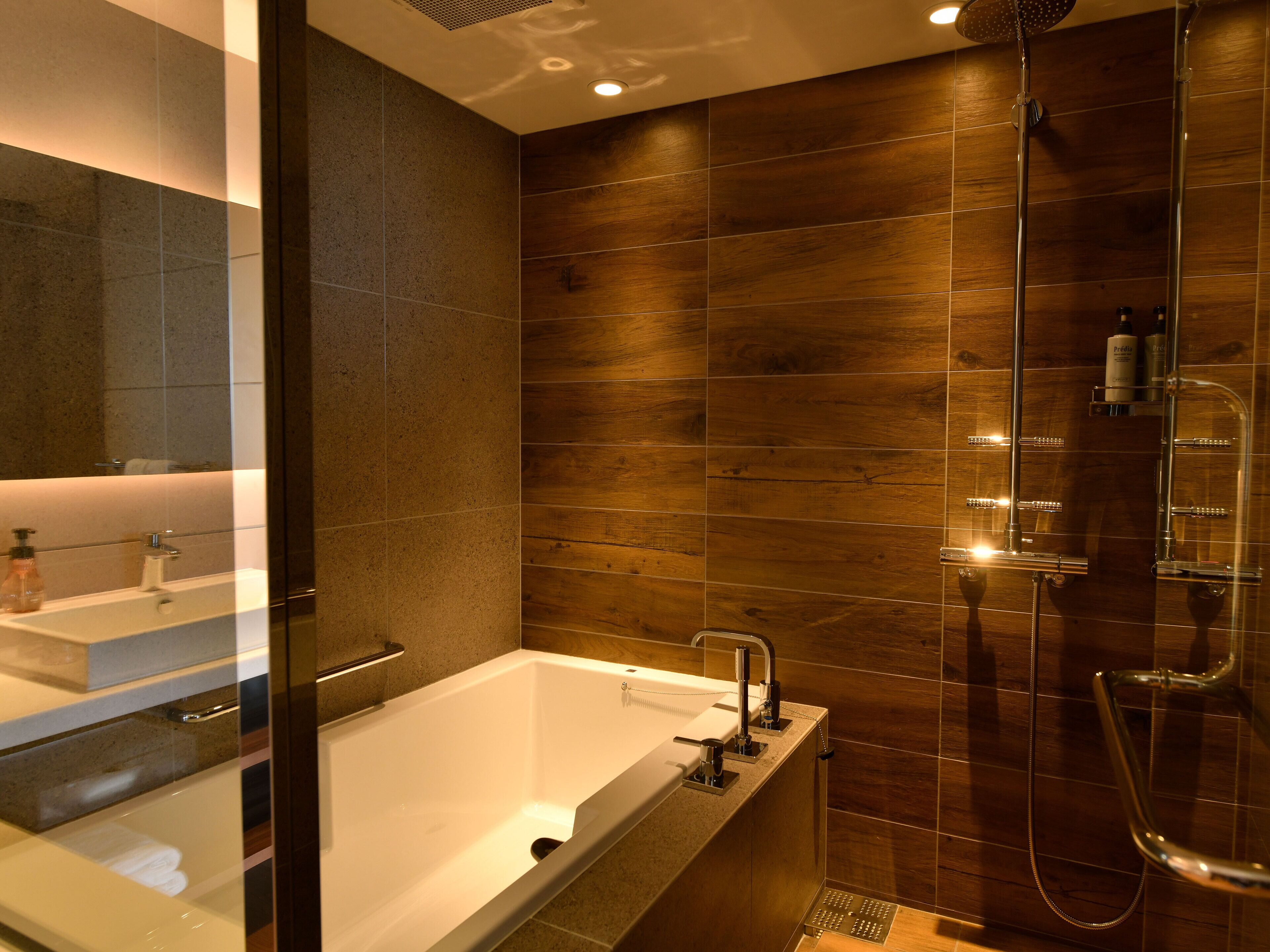 A modern bathroom with a bathtub, a shower, and a large mirror.