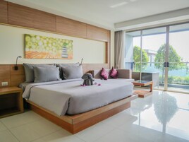 Una habitación de hotel moderna con una cama grande, un sofá y un balcón con vistas.