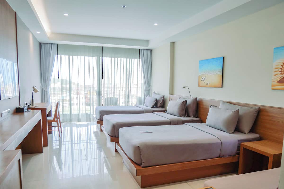 A hotel room with two beds, a desk, and a chair.