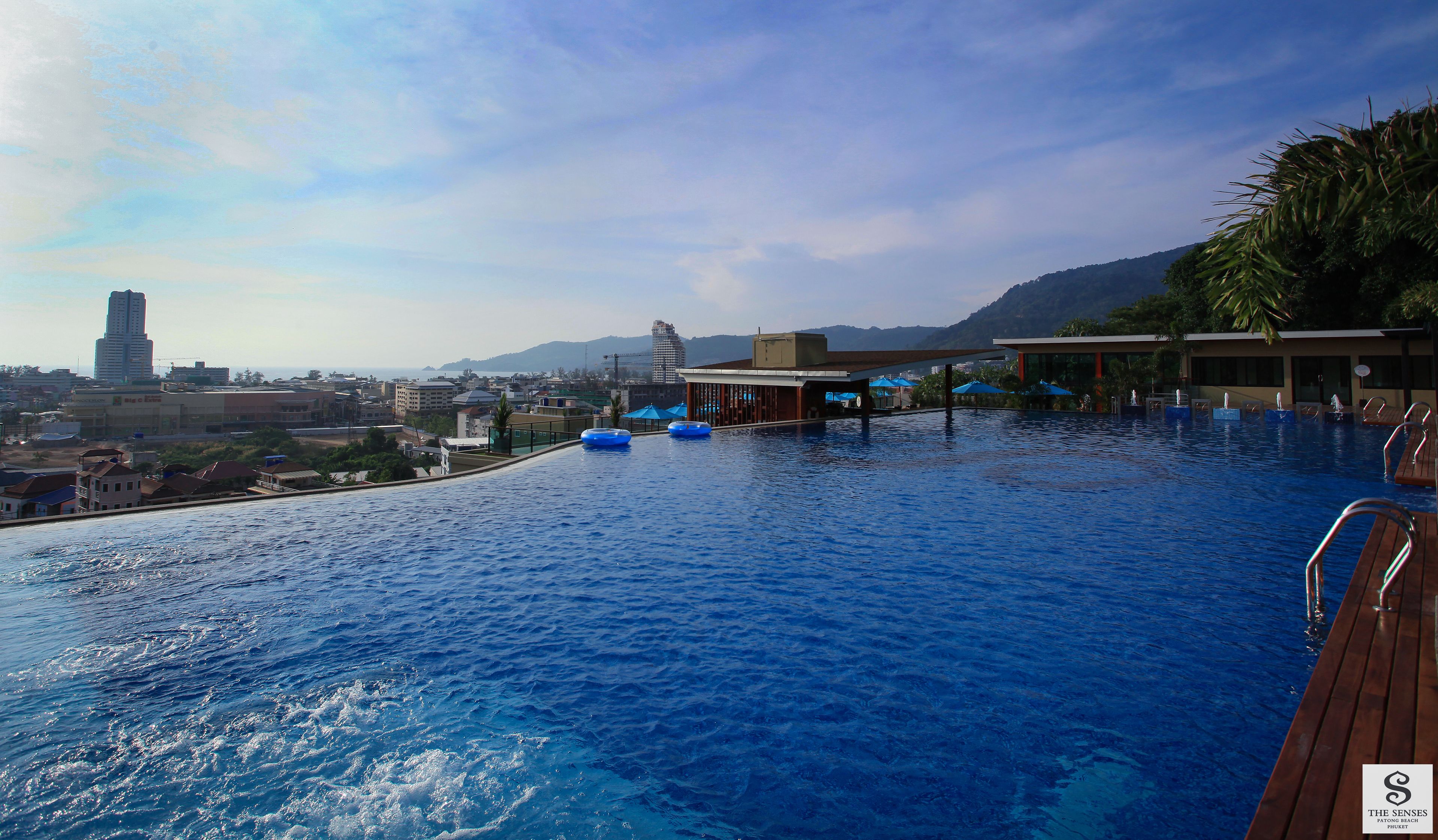 Una piscina con vistas a la ciudad y montañas al fondo.