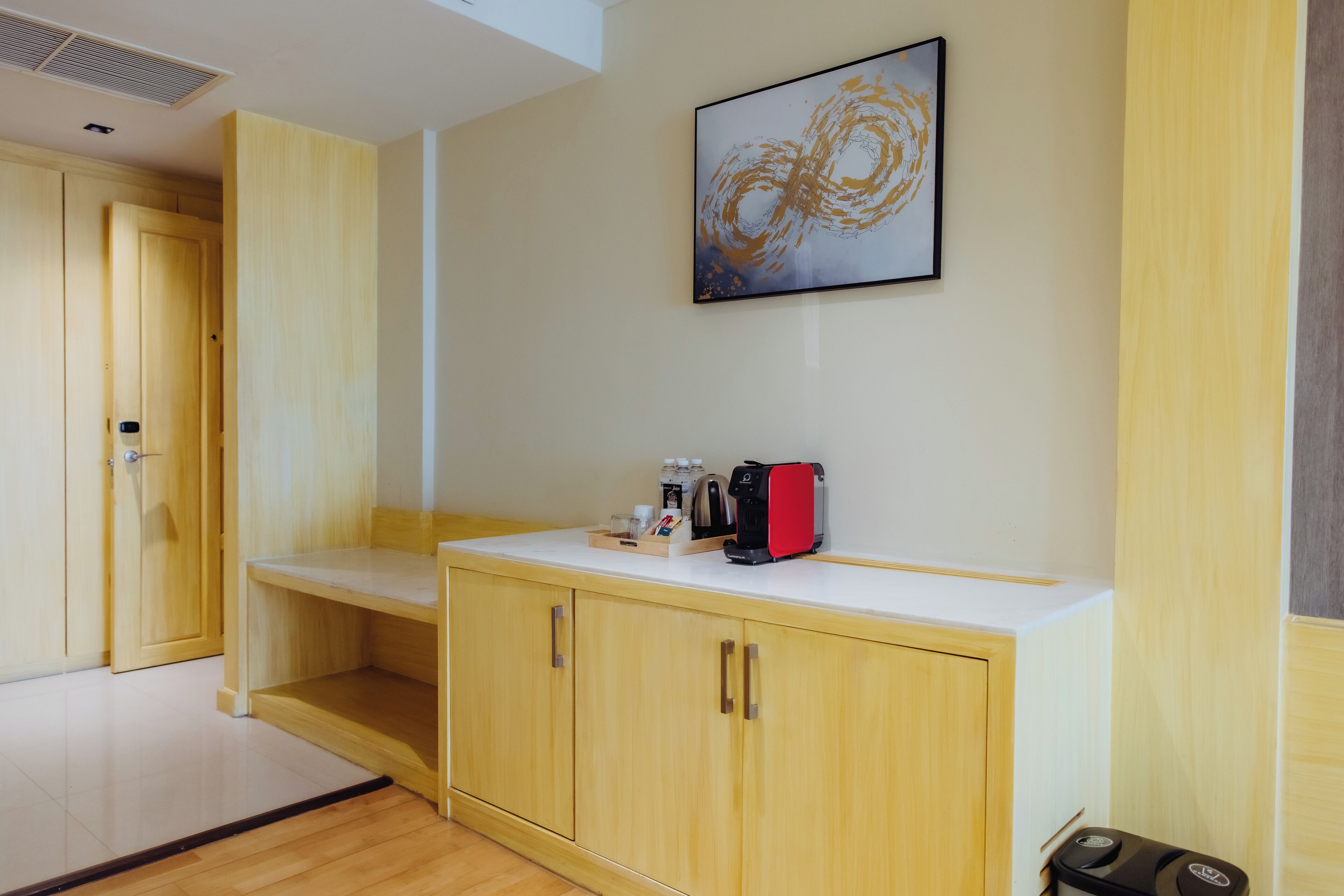 Ein Hotelzimmer mit Holzausstattung, einer weißen Arbeitsplatte und einer Kaffeemaschine.