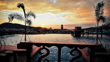 Una piscina al aire libre, sombrillas, tumbonas