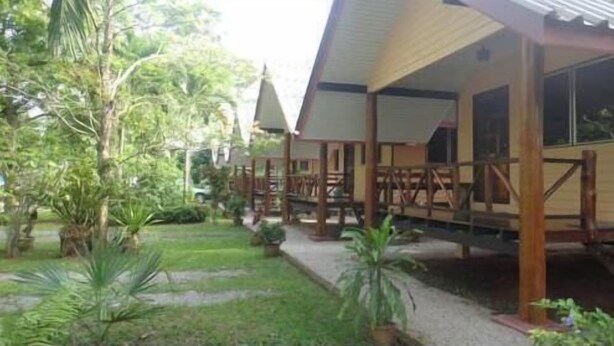 A wooden structure with a covered porch and a garden area with potted plants. - Baan Tai Rom Yen Resort (Surat Thani)