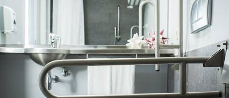A modern bathroom with a toilet, a sink, a mirror, and a towel rack.