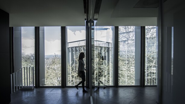 A spacious room with large windows offering a view of trees and a building. - Centre Esplai Hostel (El Prat de Llobregat)