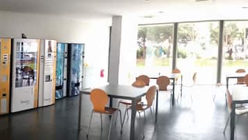 Un vestíbulo amplio con mostrador de recepción, zona de estar y máquinas expendedoras.