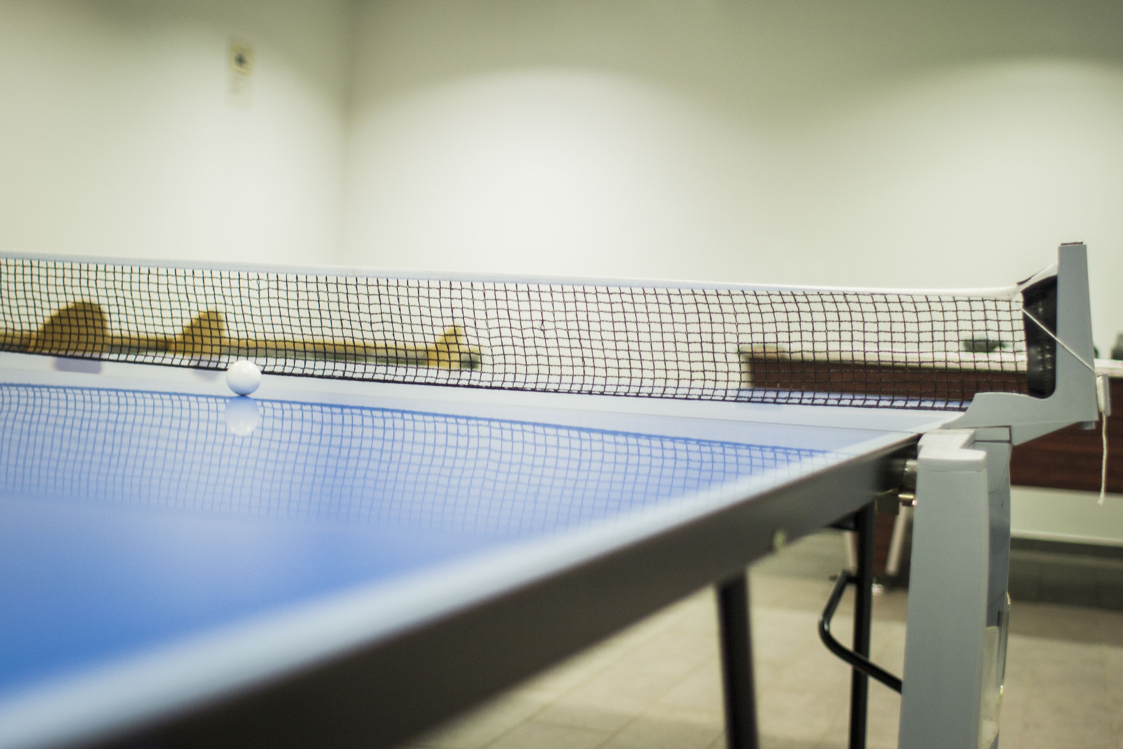 Ein Pingpongtisch mit Netz, Ball und Tischgestell.