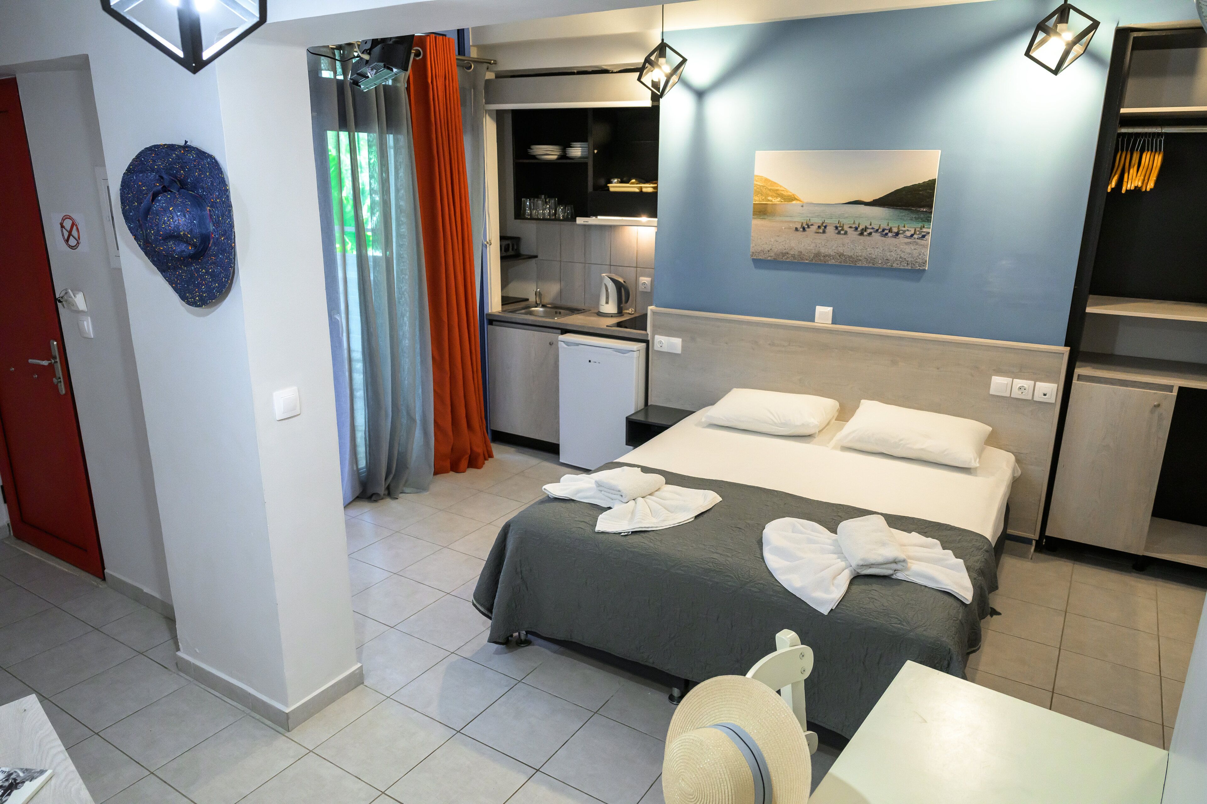 Une chambre d’hôtel avec un lit, une petite kitchenette, une salle de bain et une vue sur la plage.